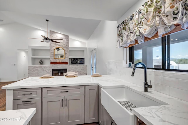 35005 N Central Ave, Phoenix, AZ 85086 - kitchen with a sink, a ceiling fan, open floor plan, light stone counters, and lofted ceiling