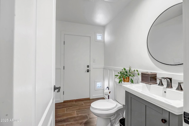 35005 N Central Ave, Phoenix, AZ 85086 - half bathroom with wainscoting, toilet, wood finish floors, vanity, and a decorative wall