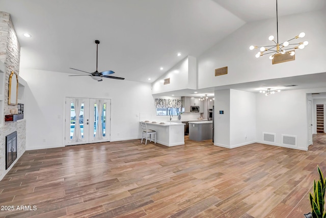 35005 N Central Ave, Phoenix, AZ 85086 - unfurnished living room featuring a chandelier, high vaulted ceiling, a fireplace, a ceiling fan, and light wood-style floors