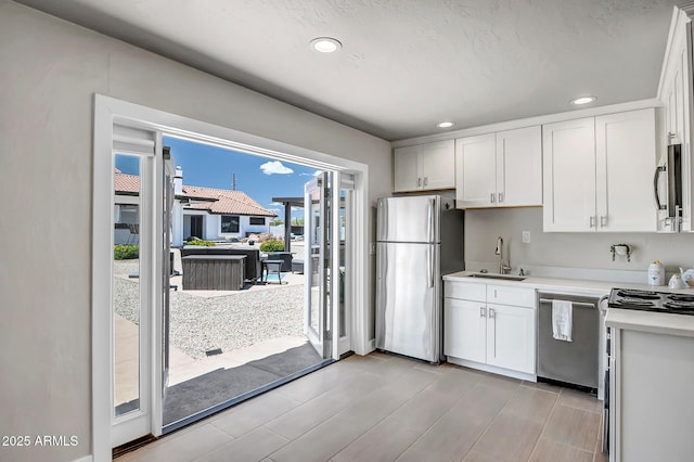 35005 N Central Ave, Phoenix, AZ 85086 - kitchen with stainless steel appliances, a sink, light countertops, white cabinets, and recessed lighting