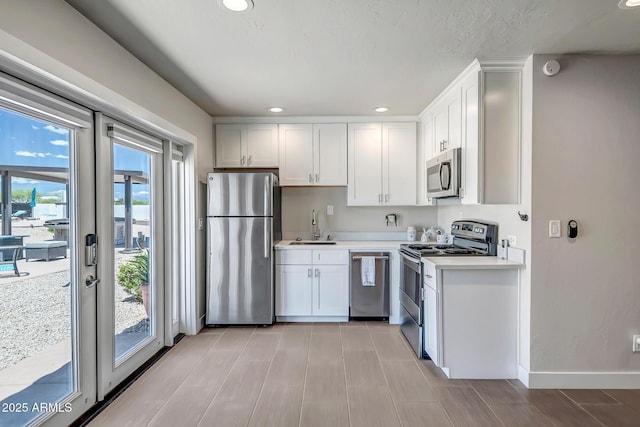 35005 N Central Ave, Phoenix, AZ 85086 - kitchen featuring appliances with stainless steel finishes, a sink, light countertops, recessed lighting, and white cabinets