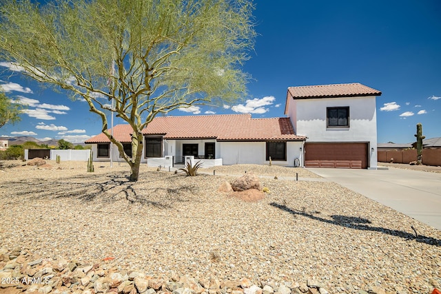 35005 N Central Ave, Phoenix, AZ 85086 - mediterranean / spanish-style home with an attached garage, a tiled roof, stucco siding, concrete driveway, and fence