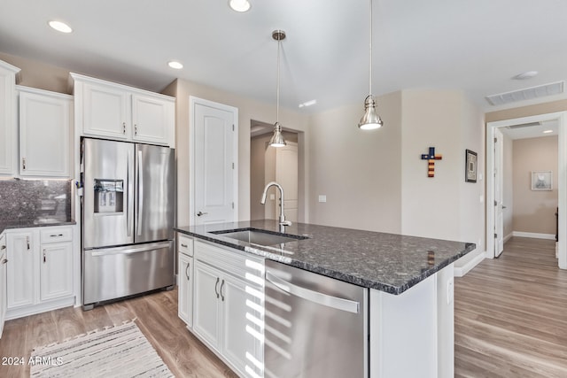 kitchen with stainless steel appliances, sink, pendant lighting, a center island with sink, and white cabinetry