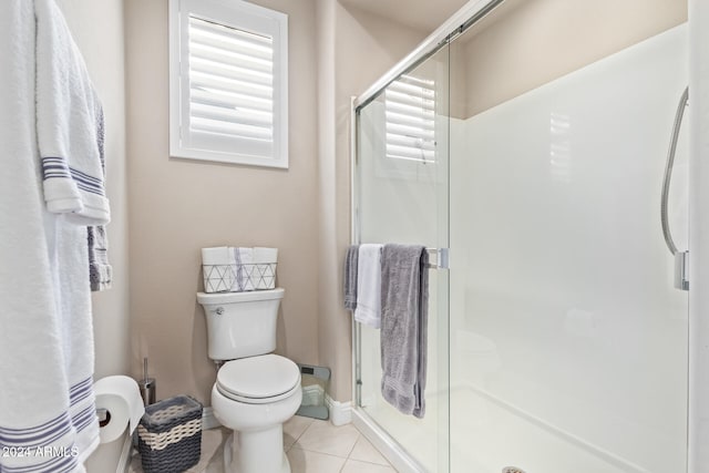 bathroom featuring tile patterned flooring, toilet, and walk in shower