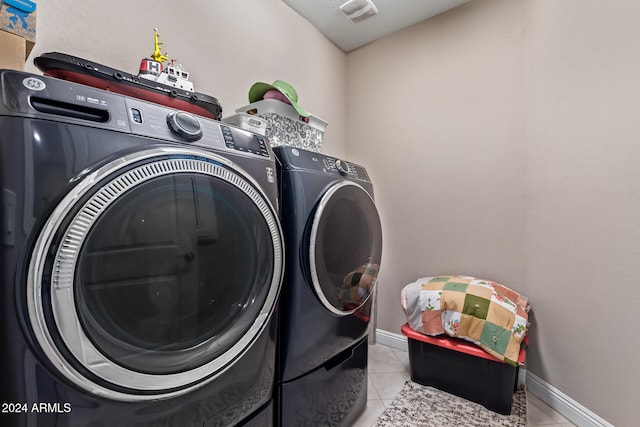 washroom with light tile patterned floors and washer and dryer