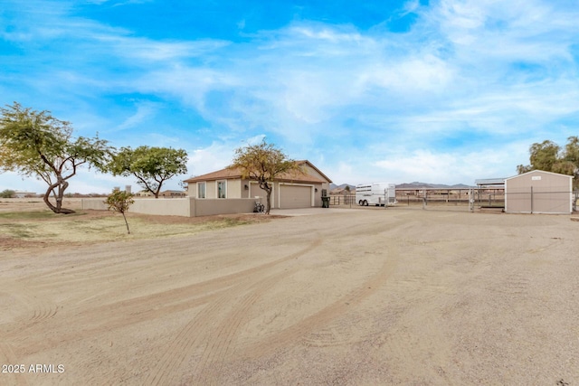 view of yard featuring fence, driveway, and an attached garage