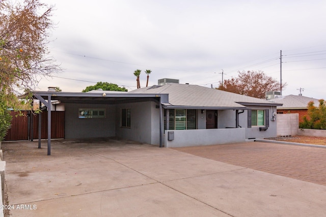 ranch-style home with a carport and cooling unit