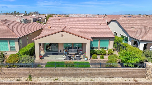 back of house with a patio area, stucco siding, a tile roof, and a fenced front yard