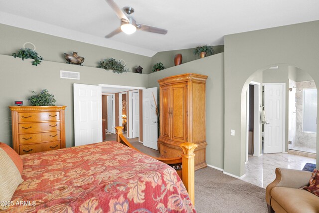 bedroom featuring visible vents, a ceiling fan, arched walkways, lofted ceiling, and light colored carpet