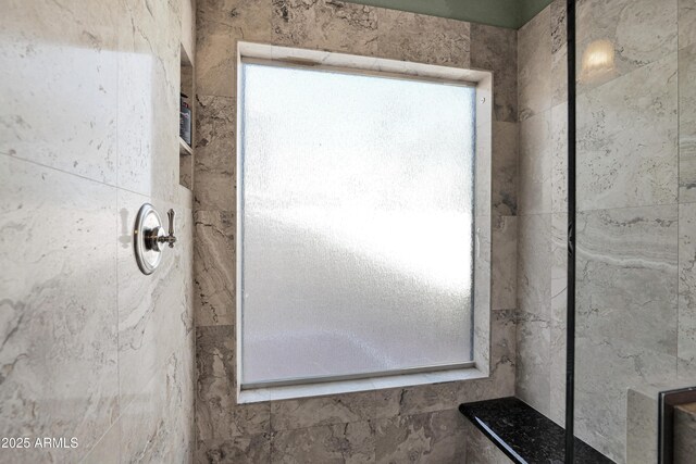 bathroom featuring plenty of natural light and tiled shower