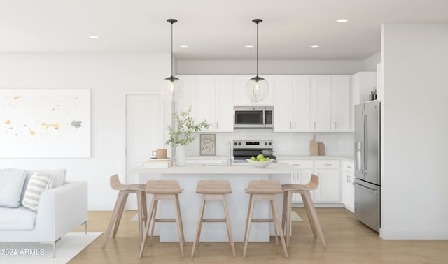 kitchen featuring tasteful backsplash, white cabinetry, hanging light fixtures, a kitchen breakfast bar, and stainless steel appliances