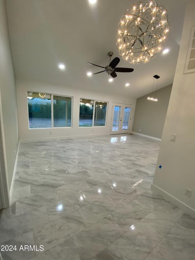 unfurnished room featuring lofted ceiling, french doors, and ceiling fan with notable chandelier