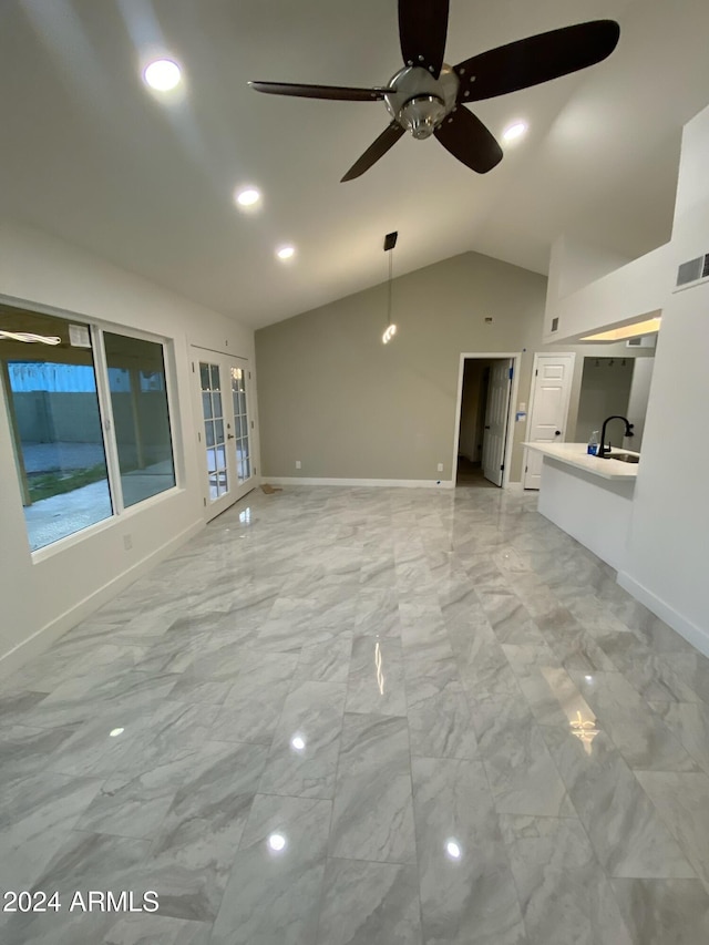 unfurnished living room with french doors, vaulted ceiling, ceiling fan, and sink