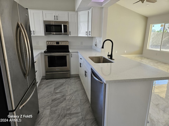 kitchen with kitchen peninsula, white cabinetry, sink, and appliances with stainless steel finishes