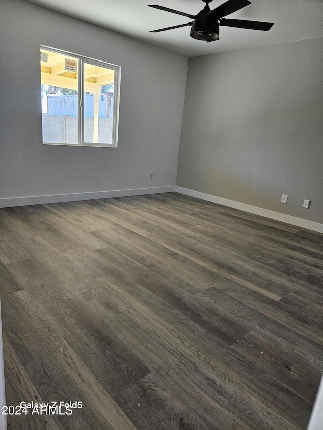 spare room with ceiling fan and dark wood-type flooring