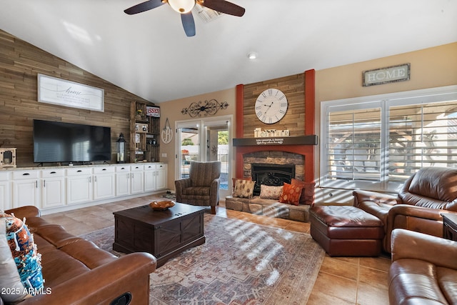 tiled living room featuring ceiling fan, wooden walls, lofted ceiling, and a fireplace