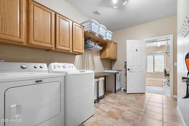 laundry area with cabinets, washing machine and clothes dryer, and light tile patterned floors