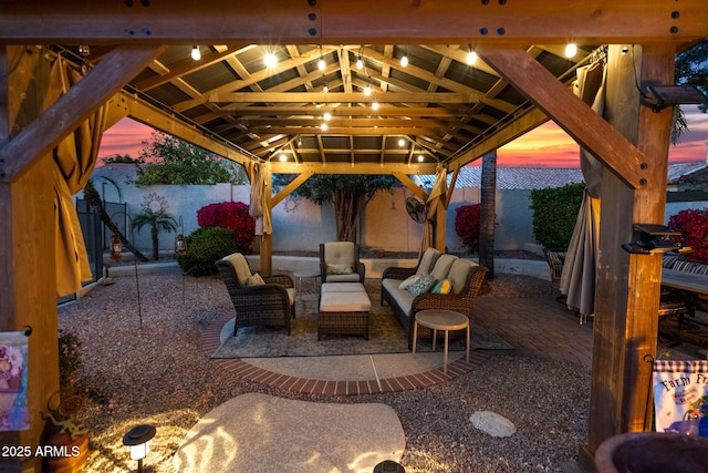 patio terrace at dusk featuring an outdoor living space and a gazebo