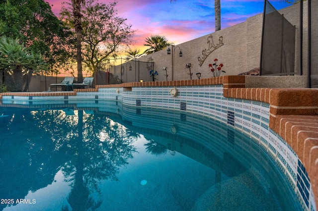 view of pool at dusk