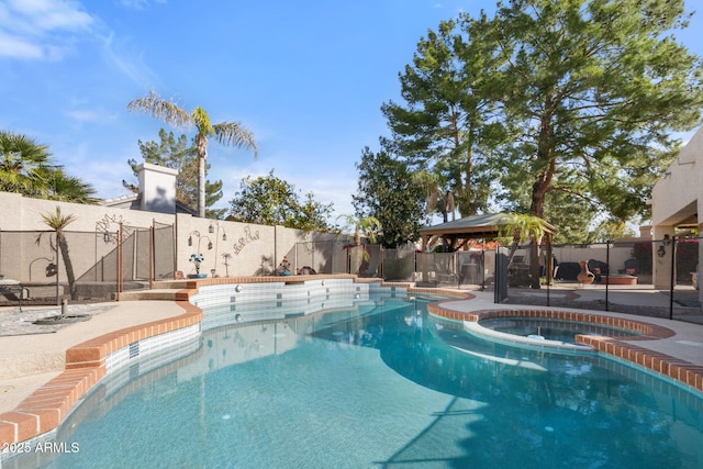 view of swimming pool featuring a gazebo and an in ground hot tub