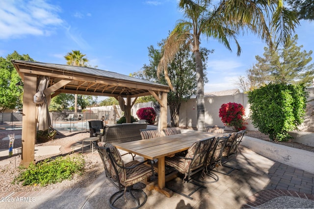 view of patio / terrace featuring a fenced in pool and a gazebo