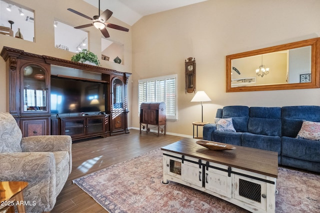 living room featuring dark hardwood / wood-style flooring, ceiling fan with notable chandelier, and high vaulted ceiling