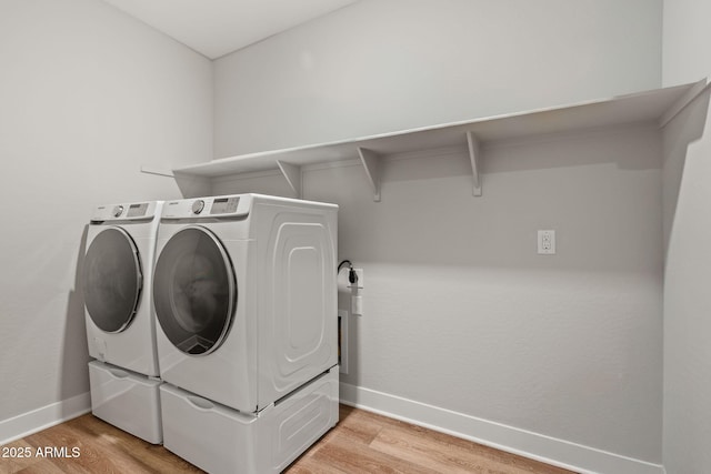 clothes washing area with hardwood / wood-style flooring and independent washer and dryer