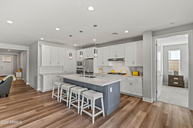 kitchen with stainless steel appliances, sink, and white cabinets