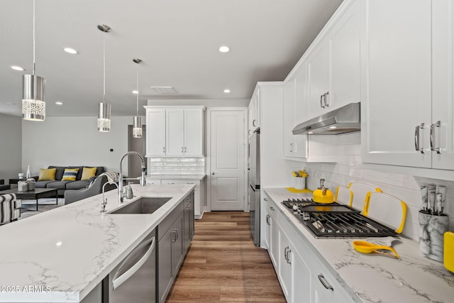 kitchen with white cabinetry, sink, and decorative light fixtures