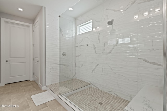 bathroom featuring tile patterned flooring and a tile shower