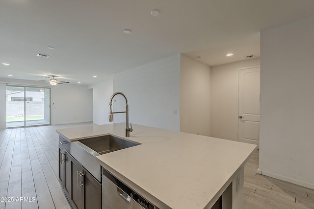 kitchen with a sink, wood tiled floors, open floor plan, a ceiling fan, and recessed lighting