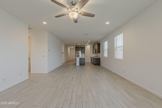 unfurnished living room with light wood-style floors, a ceiling fan, recessed lighting, and baseboards