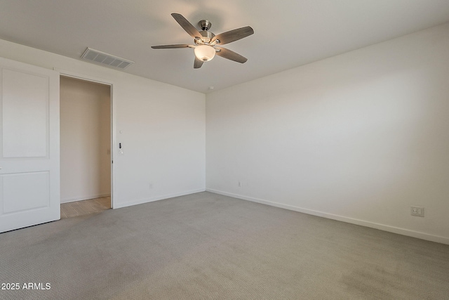 spare room featuring carpet floors, ceiling fan, and baseboards