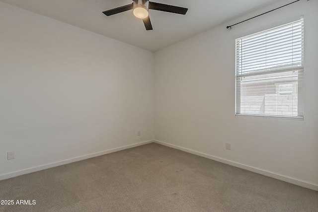 empty room with a ceiling fan, light carpet, and baseboards