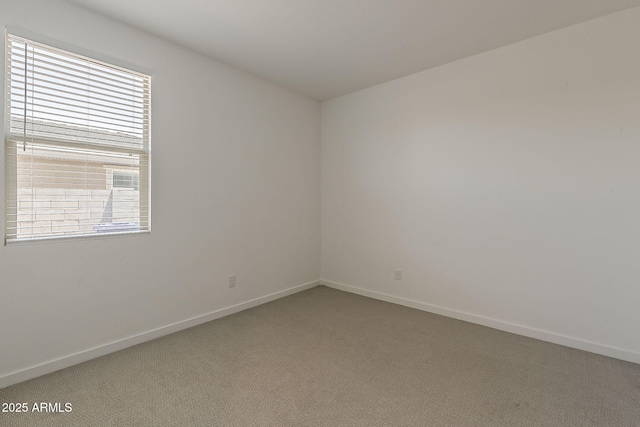 carpeted spare room featuring baseboards