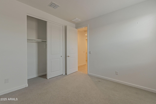 unfurnished bedroom with light carpet, baseboards, and a closet