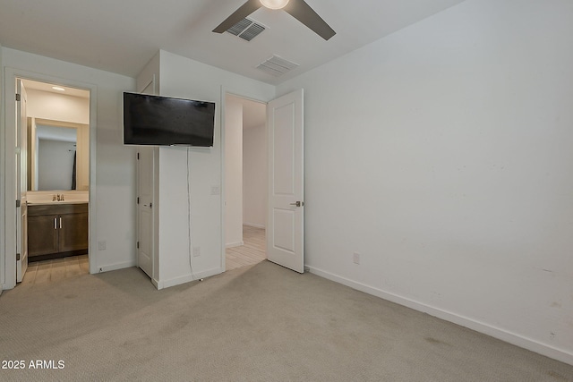 unfurnished bedroom with light carpet, baseboards, a sink, connected bathroom, and ceiling fan