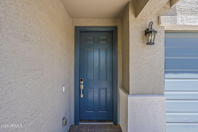 view of exterior entry with stucco siding