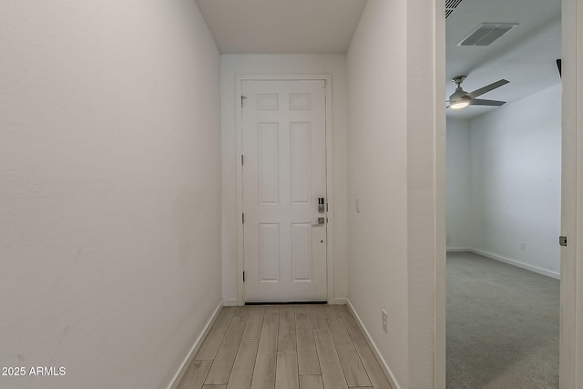 hallway with baseboards and light wood-style floors