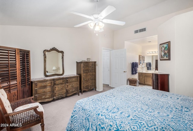 carpeted bedroom featuring ensuite bathroom, vaulted ceiling, and ceiling fan