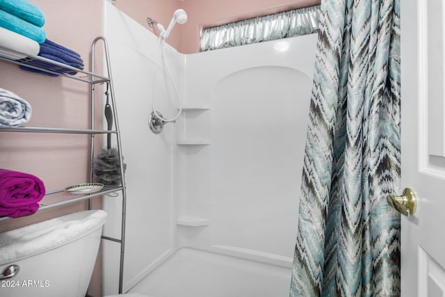 bathroom with toilet and a shower with shower curtain