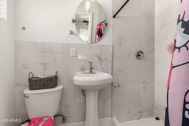 bathroom with toilet, tile walls, and a shower with shower curtain