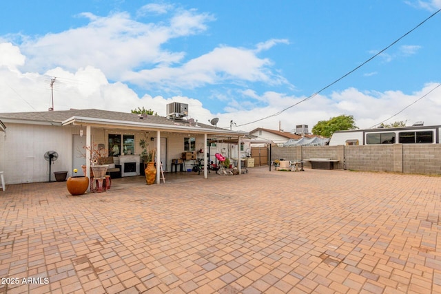 rear view of house featuring central AC unit and a patio