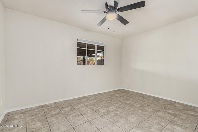 spare room with ceiling fan and light tile patterned floors