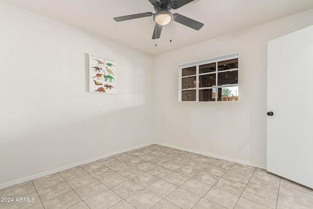 tiled empty room featuring ceiling fan