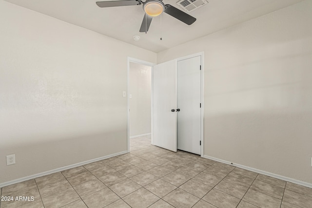 tiled empty room featuring ceiling fan