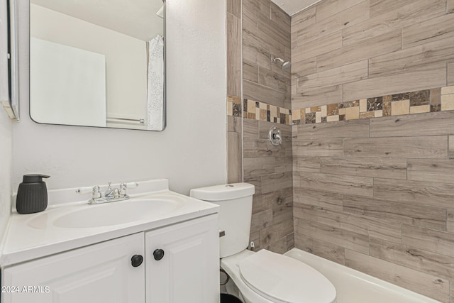 bathroom featuring toilet, vanity, and a tile shower