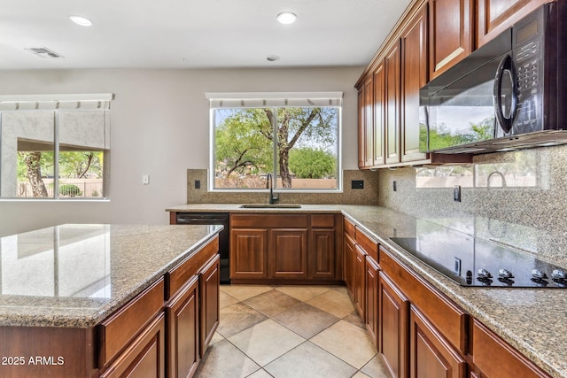 kitchen featuring a healthy amount of sunlight, a sink, tasteful backsplash, and black appliances