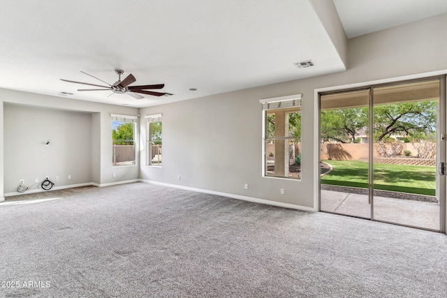 carpeted empty room with a ceiling fan, baseboards, and visible vents