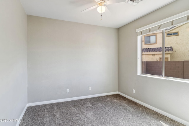 carpeted spare room with baseboards, ceiling fan, and visible vents